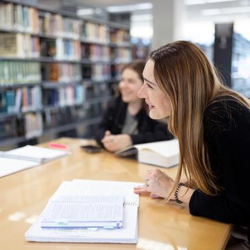 student sitting at a table at the Dorraine Zief Law Library